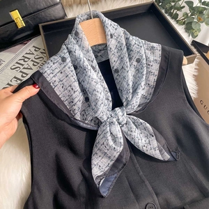 Elegant polka dot and plaid chiffon square scarf styled on a wooden hanger with apparel