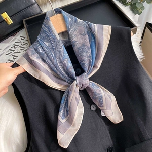 Classic blue paisley silk scarf styled on a black vest with premium aesthetic fashion