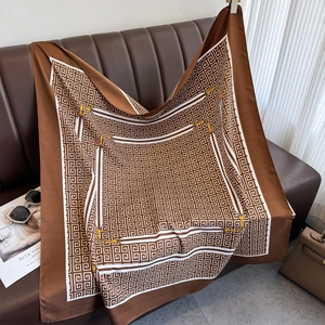Detail of square silk scarf featuring a brown geometric labyrinth and golden chain motifs