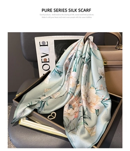 Detailed texture of mint green silk scarf featuring realistic floral prints and soft sheen