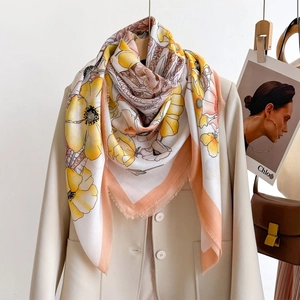 Floral print oversized silk scarf with frayed edges styled on a beige blazer jacket