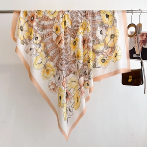 Detailed view of lightweight floral scarf featuring orange anemone prints and delicate tassels