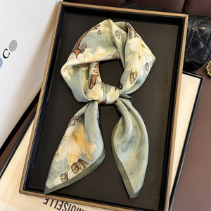 Floral print mulberry silk scarf in sage green displayed on a luxury jewelry tray