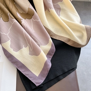 Detail of floral printed silk scarf showing intricate twill weave texture and elegant draping