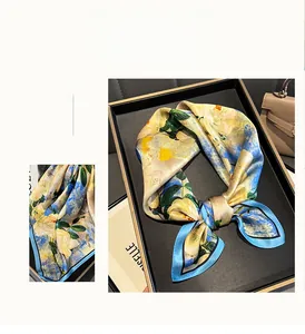Close-up of yellow and blue floral silk square scarf with elegant satin luster finish