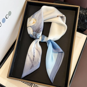 Detail of silk square scarf with vintage floral print in blue and cream colors