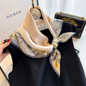 Floral silk square scarf with purple flowers and white camellia brooch on black top