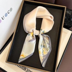 Floral silk square scarf with yellow flowers and beige base shown on a luxury tray