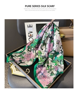 Detail of silk square scarf featuring artistic purple floral prints and smooth texture