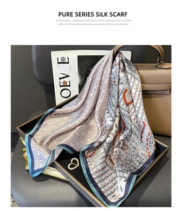 Détail d'un carré de soie aux motifs paisley disposé sur un plateau noir haut de gamme