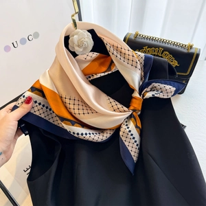 Close-up of geometric pattern silk scarf with orange stripes and blue diamond mesh texture