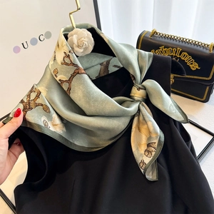 Elegant 65cm silk scarf with magnolia print on grey-green satin, styled on a garment
