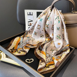 Détail d'un foulard en soie aux motifs papillons sur un sac à main en cuir de luxe