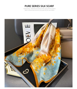 Artistic detail of premium silk scarf featuring abstract painting texture and orange border