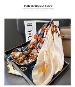 Detail of silk scarf with vintage floral print in orange and green on elegant tray