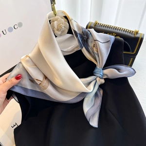Elegant silk scarf with floral prints styled on black top for a sophisticated look