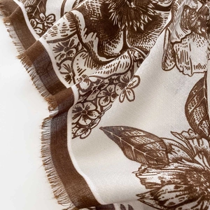 Close-up of floral pattern and fringe edge detail on a lightweight cotton linen scarf