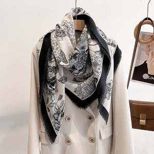 Black and white floral square scarf with fringe on a beige double-breasted blazer