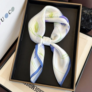 Macro detail of silk scarf featuring lotus floral print and premium satin texture