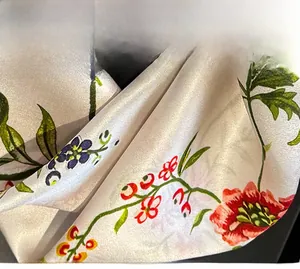 Vue détaillée de la couture surjetée raffinée sur le bord du foulard en soie fleurie