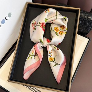Détail d'un foulard en soie à imprimé floral avec bordure rose élégante et brillante