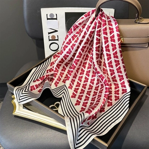 Détail macro d'un foulard en soie avec motifs papillons rouges et bords rayés