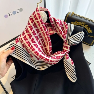 Détail du foulard en soie avec imprimé papillon rouge et bord à rayures noires