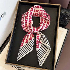 Foulard en soie avec imprimé papillons rouges et bordure rayée sur un plateau chic