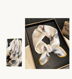 Dettaglio foulard in 100% seta con motivi di ginkgo e bordi gialli vivaci
