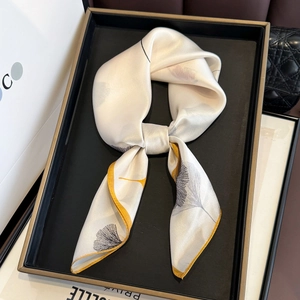 Dettaglio foulard in seta con stampa a foglie di ginkgo e bordo giallo acceso