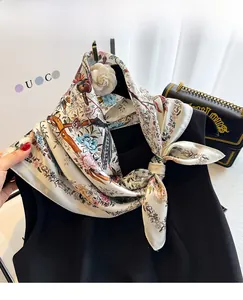 Detail of premium silk scarf featuring delicate floral and bird print on satin fabric