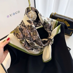 Vintage floral silk scarf with butterfly pattern and green hem on a black sleeveless top