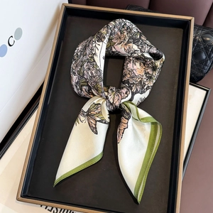 Elegant vintage silk scarf with floral butterfly print on a luxury display tray