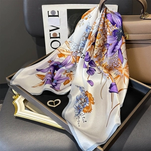 Elegant floral silk square scarf displayed with high-end luxury accessories for women