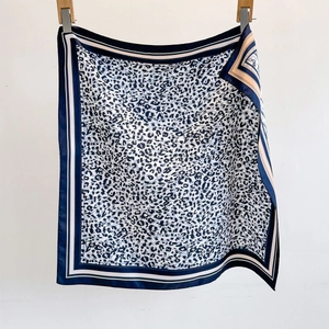 Leopard print silk square scarf with blue and gold geometric borders on white background