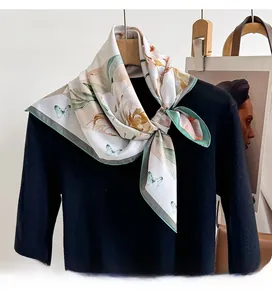 Close-up of floral silk scarf tied on a black knit sweater with butterfly pattern