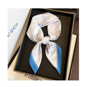 Détail d'un foulard en soie avec bordure bleue et motifs floraux au décor luxueux