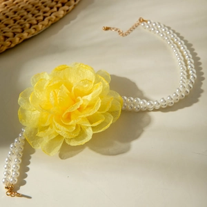 Detail of yellow organza flower on double-strand white pearl necklace with gold clasp