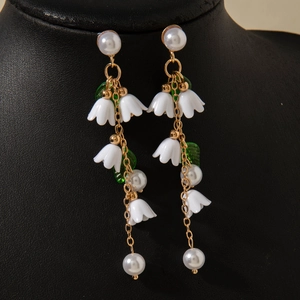 Detailed close-up of long tassel lily of the valley earrings with white pearls