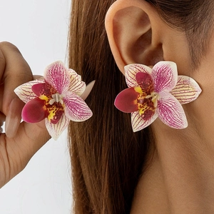 Detail van levendige paarse en gele orchidee oorbellen met bloemblad texturen