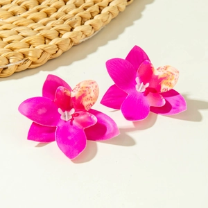 Detailopname van roze orchidee oorbellen met zijden bloemblaadjes en geel accent