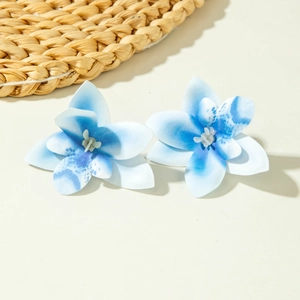 Detail van blauwe gradiënt orchidee bloem oorbellen met een bohemien zomer vakantie vibe