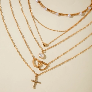Collier doré multicouches orné de perles, de cœurs et d'un pendentif croix brillant