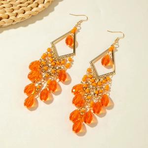 Detail of bohemian orange bead fringe earrings with geometric frames and long tassels