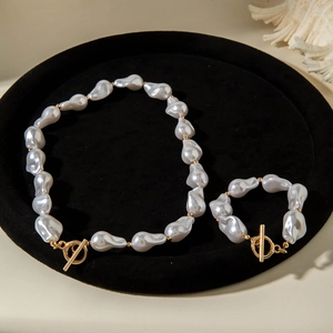 Close-up of Baroque irregular pearls with golden OT toggle clasp on a black velvet tray