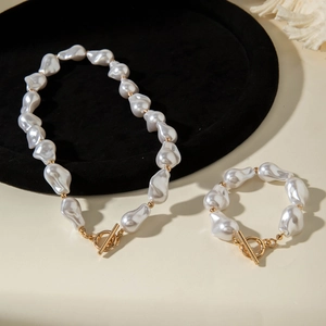 Detailed macro view of baroque pearl necklace and bracelet set with golden OT clasp closure