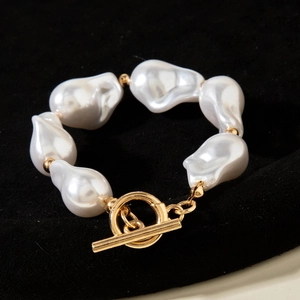 Detailed macro view of baroque irregular pearls with a golden toggle OT clasp closure