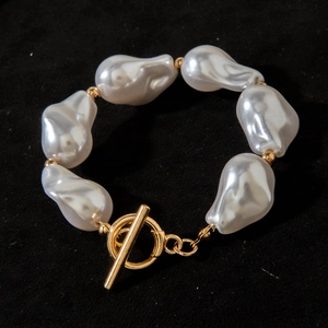 Detailed macro view of baroque irregular pearls and golden toggle clasp on necklace