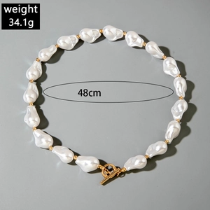 Detail of baroque irregular pearl necklace with gold beads and T-bar toggle clasp