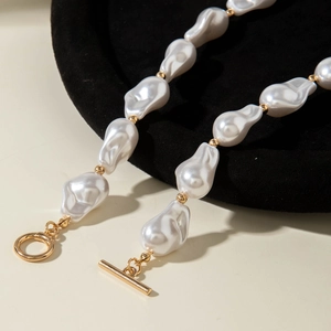 Close-up of baroque pearls with golden beads and a vintage OT toggle clasp detail